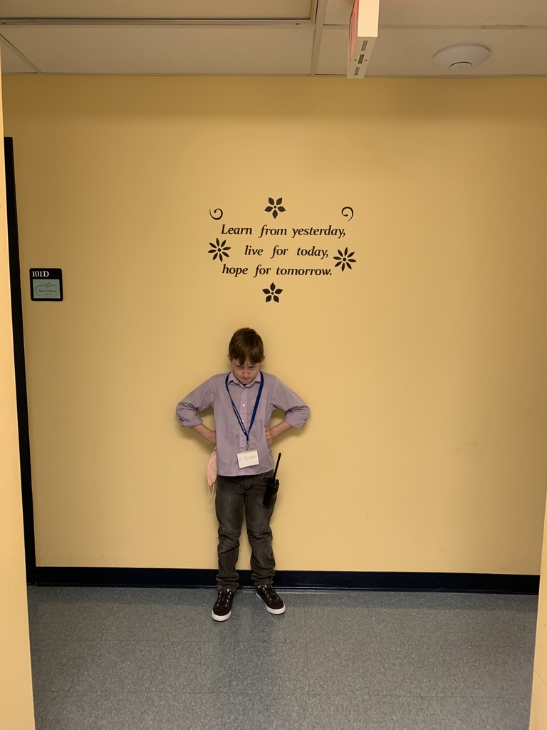 Student standing in front of a wall with his hands on his hips