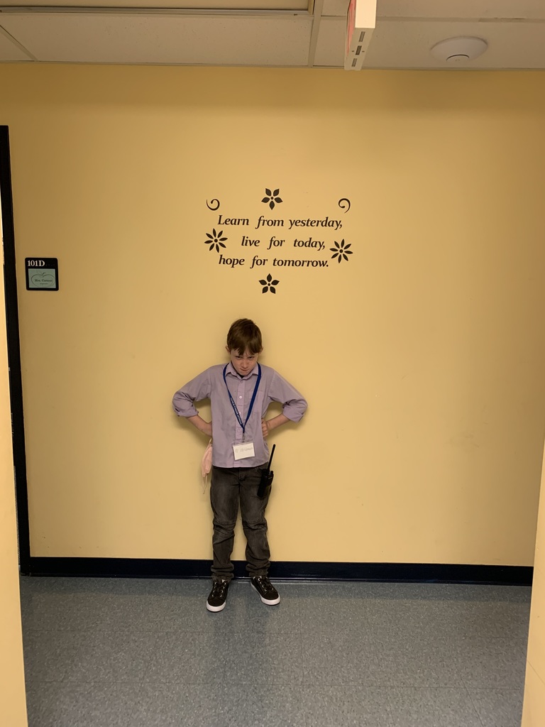 Student standing in front of a wall with his hands on his hips