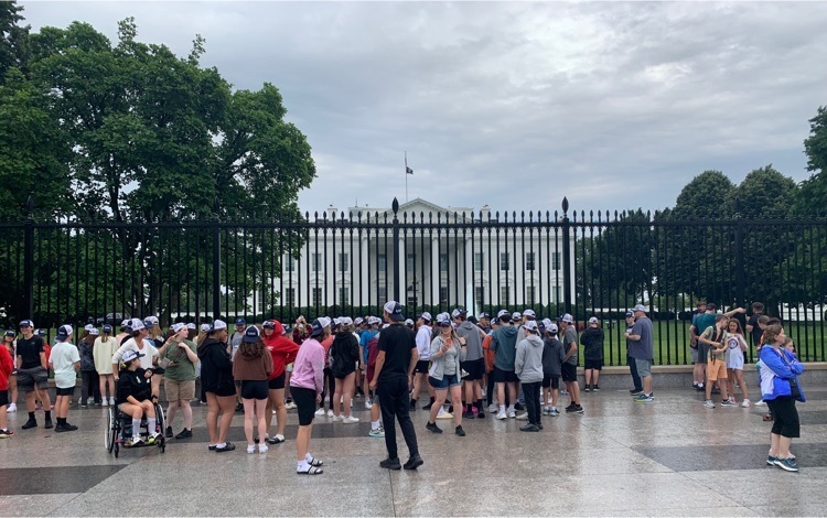 students standing outside the fence looking at the White House