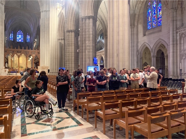 the national cathedral. students standing between the pews 