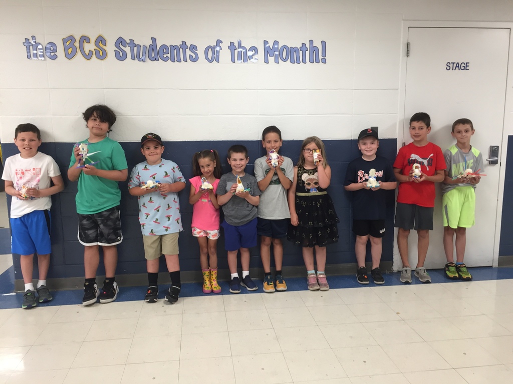 Eight students holding their egg drop projects