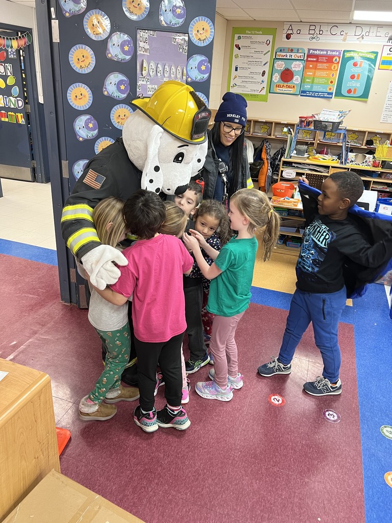 Students hugging Sparky the Fire Dog
