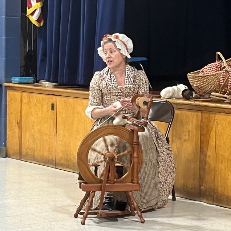 colonial women at a spinning wheel