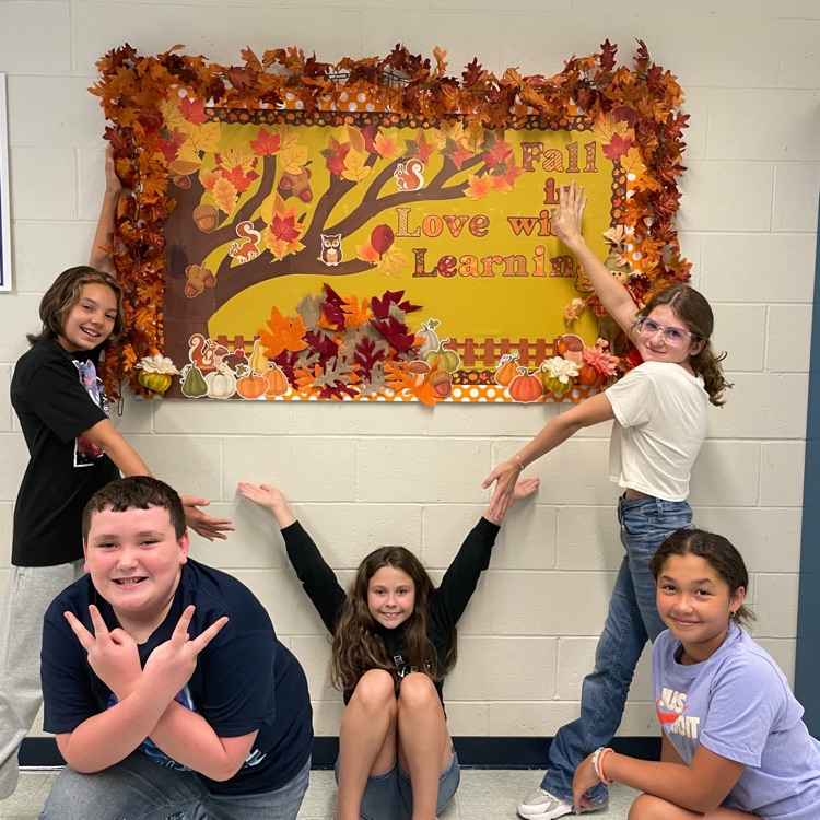 students in front of a bulletin board